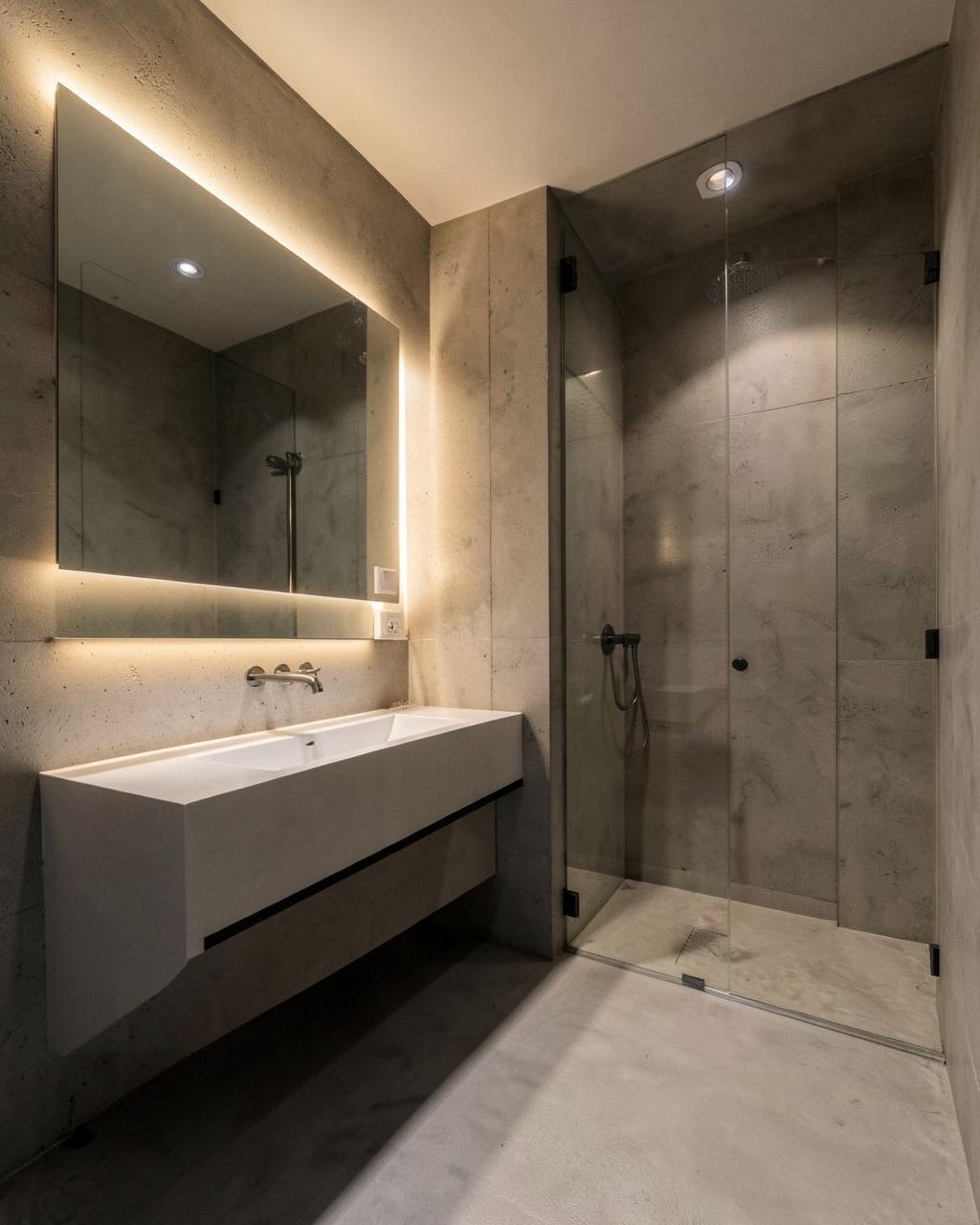 Baño minimalista con paredes de microcemento y ducha de obra